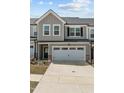 Beautifully designed townhome with two-car garage, stone accents, and grey vertical siding at 486 Autumn Rain St, Cary, NC 27519