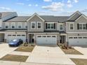 Charming townhome featuring a two-car garage, grey siding, and beautifully manicured landscaping at 486 Autumn Rain St, Cary, NC 27519