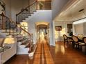 Bright foyer with hardwood floors, staircase with iron spindles, and views to the dining room at 502 Willowmere Ct, Cary, NC 27513