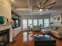 Spacious living room featuring coffered ceilings, hardwood floors, a fireplace, and large windows at 502 Willowmere Ct, Cary, NC 27513