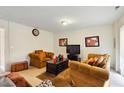 Bright living room featuring comfortable armchairs, a TV, and elegant wall decor at 5163 Sandy Banks Rd, Raleigh, NC 27616