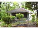 Side view of a home with a covered porch and overgrown landscaping at 537 Homeland Ave, Durham, NC 27707