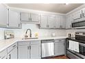 This updated kitchen features grey cabinetry, stainless appliances, subway tile backsplash and quartz countertops at 5500 Fortunes Ridge Dr # 72A, Durham, NC 27713