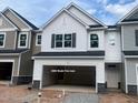New construction two-story townhome with two-car garage and white siding and black shutters at 6002 Shade Tree Ln, Durham, NC 27703