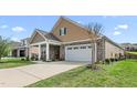 Charming home featuring a two-car garage, stone accents, covered entryway, and driveway at 667 Ashley Woods Dr, Gibsonville, NC 27249