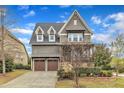 Craftsman-style home featuring a two-car garage, stone accents, and manicured landscaping at 8121 Greys Landing Way, Raleigh, NC 27615