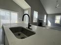 Close up of kitchen island sink and faucet with modern black fireplace and vaulted ceilings in background at 825 Long Ave, Rocky Mount, NC 27801