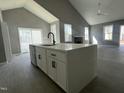 Kitchen island with white countertop, black faucet and modern black cabinet pulls under high vaulted ceilings at 825 Long Ave, Rocky Mount, NC 27801