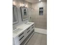 Modern bathroom featuring double sinks, sleek white cabinetry, and a luxurious walk-in shower at 905 Ardmore Dr, Durham, NC 27713