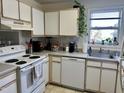 Cozy kitchen features white cabinets, appliances, sink, and a window bringing in natural light at 1140 Carlton Ave # 201, Raleigh, NC 27606