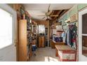 A crammed storage room with various items, revealing an open ceiling and wood-paneled walls at 1203 Brookside Dr, Raleigh, NC 27604