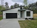 Stunning modern home with black garage door, stone accents, and a well-maintained yard at 124 Horseman Dr, Louisburg, NC 27549
