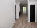 Hallway with wood floors and white walls leads into a room with sliding glass doors at 124 Horseman Dr, Louisburg, NC 27549