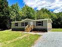 Charming single-story home with gray siding, fresh wooden steps, and gravel driveway at 1326 Stephens Dr, Roxboro, NC 27573