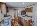 Cozy kitchen featuring wood cabinets, island, stainless steel appliances, and wood laminate flooring at 1326 Stephens Dr, Roxboro, NC 27573