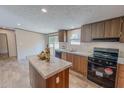 Modern kitchen featuring an island, wooden cabinetry, and updated appliances at 1326 Stephens Dr, Roxboro, NC 27573
