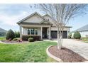 Lovely home featuring a well-manicured lawn, a driveway, and vibrant flowerbeds at 135 Brocks Trce, Burlington, NC 27215