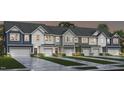 A row of newly built townhomes featuring unique, colorful facades and modern garage doors in a welcoming neighborhood at 1367 Bessie Ct, Wake Forest, NC 27587