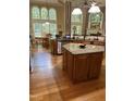 Bright kitchen boasts granite counters, stainless appliances, wooden cabinets, large windows, and a breakfast nook at 1404 Rhea Dr, Garner, NC 27529