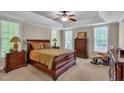 Inviting main bedroom features a large bed, dresser, ceiling fan, and multiple windows at 1404 Rhea Dr, Garner, NC 27529