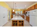 Spacious kitchen with central island, warm wood cabinetry, and modern appliances at 151 Rosedale Creek Dr, Durham, NC 27703