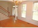 Bright entryway featuring hardwood floors, elegant chandelier, and a staircase leading to the upper level at 1623 Rogers Pointe Ln, Creedmoor, NC 27522