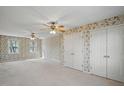 A spacious bedroom features floral wallpaper, hardwood floors, and plentiful natural light through the windows at 167 Coachmans Cove Rd, Four Oaks, NC 27524