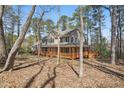 Beautiful two-story home with a large porch, nestled among mature trees and natural landscaping at 167 Coachmans Cove Rd, Four Oaks, NC 27524