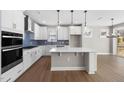 Modern kitchen with white cabinets, stainless steel appliances, subway tile backsplash, and a center island at 1801 Angelonia Way, Fuquay Varina, NC 27526