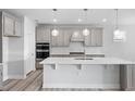 Modern kitchen featuring pendant lighting, stainless appliances, a large island, and stylish backsplash at 1805 Angelonia Way, Fuquay Varina, NC 27526