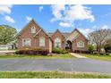 Attractive brick home featuring an inviting front entrance, arched windows, and landscaped grounds at 2011 Gibsonville Ossipee Rd, Elon, NC 27244
