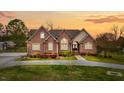 Charming brick home with well-manicured lawn during the sunset in a quiet neighborhood at 2011 Gibsonville Ossipee Rd, Elon, NC 27244