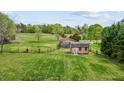 Large, grassy field with a shed building and surrounding trees at 2011 Gibsonville Ossipee Rd, Elon, NC 27244