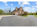 Spacious paved driveway leading to a two-story brick home with an attached garage at 2011 Gibsonville Ossipee Rd, Elon, NC 27244