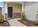 Charming front porch with stone accents, a black door, and manicured landscaping, creating a welcoming entrance at 2013 Magnolia Tree Ln, Durham, NC 27703