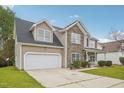 Charming two-story home featuring a stone facade, a two-car garage, and a well-maintained front yard at 2223 Lazy River Dr, Raleigh, NC 27610