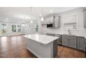 Modern kitchen featuring gray cabinets, stainless steel appliances, island and white countertops at 2304 Beeblossom Pl, Fuquay Varina, NC 27526