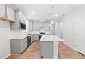 Modern kitchen featuring gray cabinets, stainless steel appliances, island and white countertops at 2304 Beeblossom Pl, Fuquay Varina, NC 27526