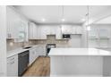Kitchen with white cabinets, stainless appliances, tiled backsplash, and a large center island at 2316 Beeblossom Pl, Fuquay Varina, NC 27526