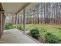 Covered back porch overlooking a lush backyard with mature trees, offering a peaceful outdoor retreat at 2411 Lynch Store Rd, Mebane, NC 27302