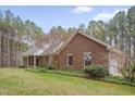Lovely brick home with manicured landscaping, mature trees, and an attached garage creating a serene setting at 2411 Lynch Store Rd, Mebane, NC 27302