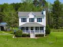 Charming two-story home with a welcoming front porch, lovely landscaping, and a well-maintained lawn at 2651 Bennett Rd, Creedmoor, NC 27522