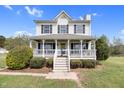 Lovely two-story house with a charming front porch, white railings, and decorative wreath at 2651 Bennett Rd, Creedmoor, NC 27522