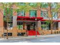 Building with an inviting entrance featuring a red awning, stairs, and well-maintained landscaping at 510 Glenwood Ave # 602, Raleigh, NC 27603