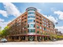 Modern multi-story brick building with large windows and balconies, under a partly cloudy sky at 510 Glenwood Ave # 602, Raleigh, NC 27603