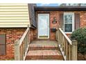 Close-up of a brick home's entrance, showcasing a white door with house number and a small porch with wooden railings at 5401 Kaplan Dr, Raleigh, NC 27606