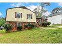 Charming two-story home with a brick and siding exterior and a lush green lawn at 5401 Kaplan Dr, Raleigh, NC 27606