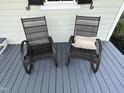 Up close, cozy rocking chairs with a decorative pillow on a stylish front porch at 65 Oglethorpe Ave, Clayton, NC 27527