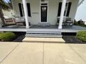 Inviting front porch with gray steps, chairs, and stylish decor at 65 Oglethorpe Ave, Clayton, NC 27527