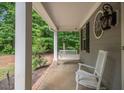 Inviting front porch with white rocking chair and swing, complemented by a unique round window at 711 Kentcie Ln, Efland, NC 27243